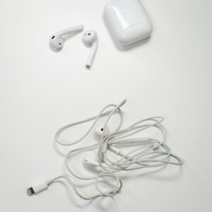 Overhead view of wireless and wired earbuds on a white background, showcasing modern audio technology.