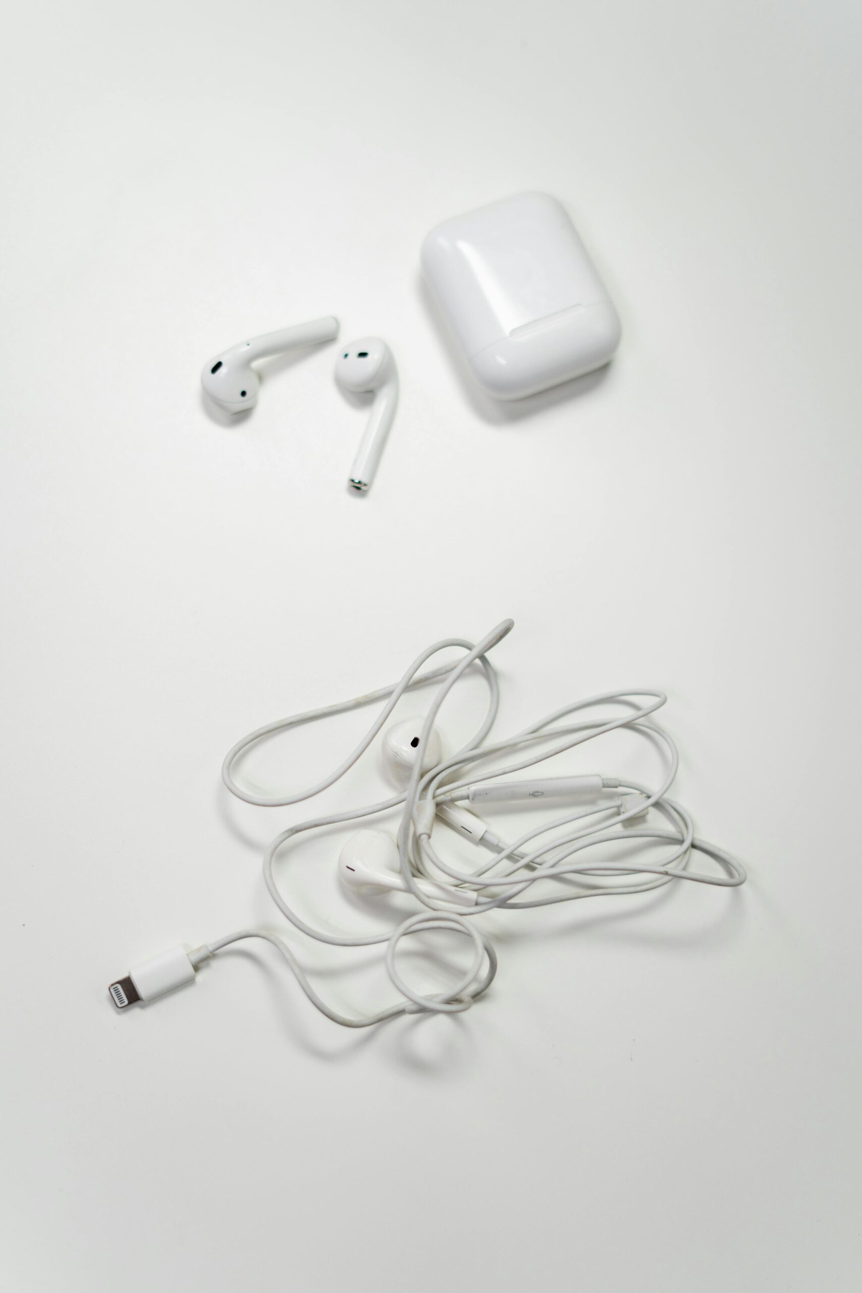 pexels photo 3945697 3945697 Overhead view of wireless and wired earbuds on a white background, showcasing modern audio technology.